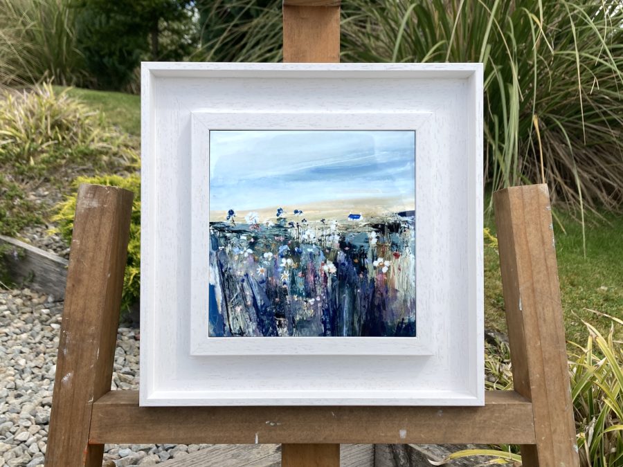 Framed ceramic tile wall art print of Scottish landscape painting featuring Highland glen and stone bothy cottage among wild flowers